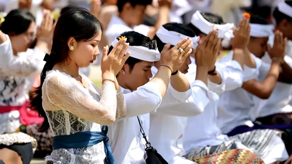 Balinese people praying together during a temple ceremony, showing spiritual connection in daily life